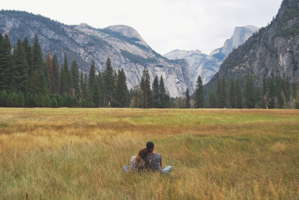 A couple enjoying a mountain view together from a meadow